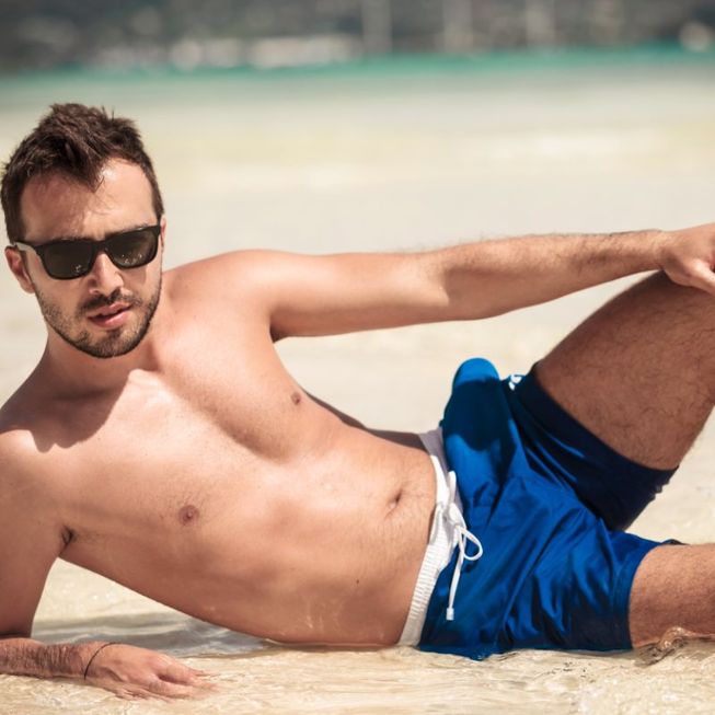 hombre con gafas de sol y bañador azul